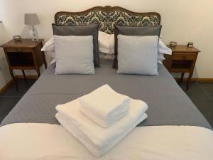 Una cama grande con almohadas blancas encima. en Les Rouges Terres Gites - La Laterie en Saint-Amand