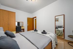 a bedroom with a large bed and a mirror at BOŽICA House with apartments in Murine