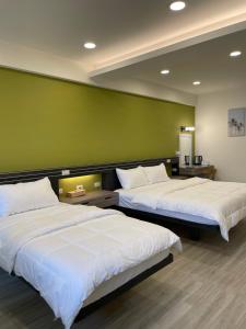 two beds in a room with a green wall at 小島上island in Dongyin