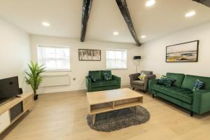 sala de estar con 2 sofás verdes y TV en Coniston House near Bolton, Appleby-in-Westmorland by Guestz, en Kirkby Thore