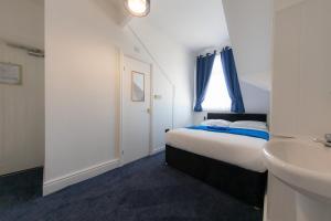 a small bedroom with a bed and a sink at The Adonis Hotel in Blackpool