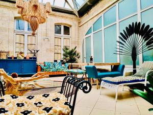 a conservatory with chairs and tables and windows at Koko & Baobab in Bordeaux