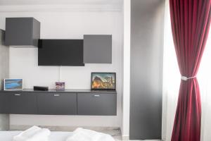 a bedroom with a tv on a white wall at Apart Hotel Center in Piatra Neamţ