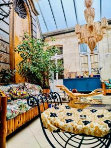 un patio con sedie, un letto e un lampadario a braccio di Koko & Baobab a Bordeaux