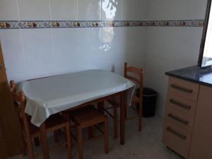 una pequeña cocina con mesa, sillas y barra. en Inmejorable para descanso, playa y montaña Ribadeo, en Ribadeo