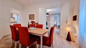 a dining room with a wooden table and red chairs at La Casa Dei Leoni in Trieste