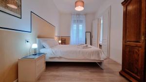 a bedroom with a white bed and a window at La Casa Dei Leoni in Trieste