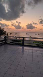 eine Person schaut bei Sonnenuntergang auf das Meer in der Unterkunft Casa beira mar de Maragogi - Al in Maragogi