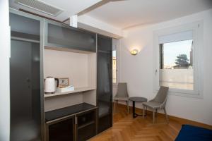 um quarto com uma mesa e cadeiras e uma janela em Padova Suites C20 em Pádua