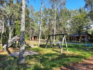 een park met een schommel en een hut bij Pinetree Cottages Log cabin in Pyhäranta