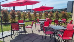 a group of tables and chairs with red chairs and umbrellas at Ace Hotel Creutzwald Saint Avold in Creutzwald-la-Croix +10 photos