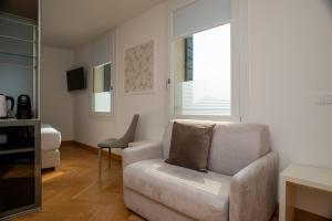 un soggiorno con una sedia e un divano di Padova Suites C20 a Padova