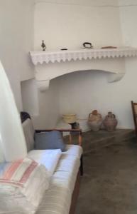 sala de estar con sofá y algunos jarrones en Traditional Village House, en Tílisos