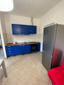 a kitchen with blue cabinets and a stainless steel refrigerator at Da Angela in Il Romito +20 photos