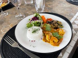 Mamoudzou的住宿－Le Passamainty Lodge，餐桌上放着一盘饭和蔬菜的食物