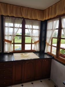 uma cozinha com duas janelas e uma bancada em La estrella em Tineo