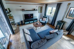 デュルビュイにあるMaison Loïcの青いソファとテレビのあるリビングルーム