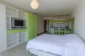 ein Schlafzimmer mit einem weißen Bett und grünen Wänden in der Unterkunft MODERNO DEPARTAMENTO CON VISTA AL LAGO in San Carlos de Bariloche