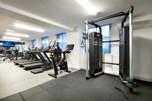 a gym with treadmills and machines in a room at Hard Rock Hotel London in London
