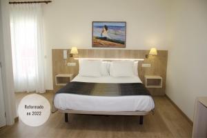 a bedroom with a large bed with white pillows at Hotel Playa de Lago in Muxia