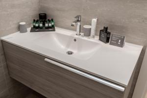 a white sink in a bathroom with bottles and cosmetics at EUROPA Hotel in Vasto