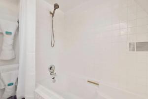 a white bath tub with a shower head in a bathroom at The Pyramid In Big Bear #2124 by Big Bear Vacations in Big Bear City +12 photos