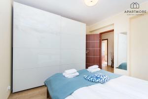 City Center - Torunska 18 by Apartmore في غدانسك: غرفة نوم عليها سرير وفوط