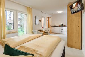 Un dormitorio con una cama y un televisor en una pared. en Thermen Appartements Gabriela, en Bad Krozingen