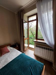 a bedroom with a bed and a large window at Квартира в самом центре in Almaty