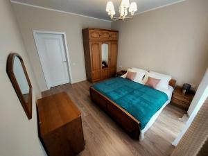 - une chambre avec un grand lit et une couverture bleue dans l'établissement Квартира в самом центре, à Almaty
