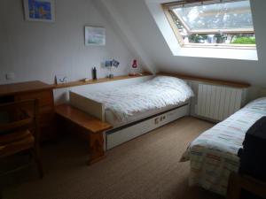 een slaapkamer met een bed, een bureau en een raam bij Villa Spacieuse avec Beau Jardin, Wifi, Port a 500m, Trinite sur Mer in La Trinité-sur-Mer