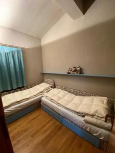 Cette chambre comprend 2 lits et une fenêtre. dans l'établissement Appartamento Les Jumeaux, à Breuil-Cervinia