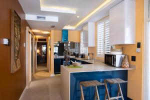 een keuken met blauwe en witte werkbladen en krukken bij Beachfront Luxury - 2 Chaka's Place in Ballito