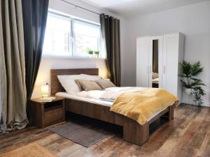 a bedroom with a large bed and a window at SB Apartment in Kołobrzeg