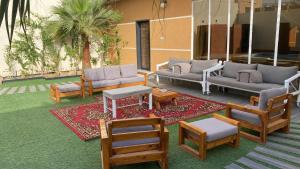 um pátio com sofás, cadeiras e uma mesa em شالية لورينزو em Buraydah