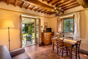 a living room with a table and chairs and a dining room at Villa Borgo San Pietro in Cortona