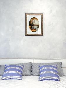 a picture hanging above a bed with blue and white pillows at B&B Stella in Rovereto