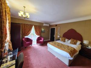 
a hotel room with a bed and a dresser at Langley Castle Hotel in Allendale Town
