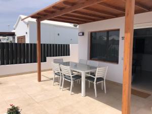 un patio con tavolo e sedie sul balcone. di ToMo a Puerto del Carmen
