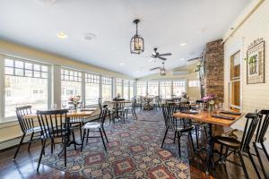 a dining room with tables and chairs and windows at The Norwich Inn in Norwich