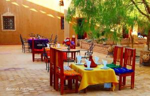 a patio with tables and chairs in a courtyard at Hotel Riad Le Petit Prince in Merzouga