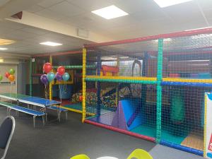 uma sala de aula com uma área de lazer com equipamento de brincar e balões em Hoburne Devon Bay Paignton L48 em Paignton