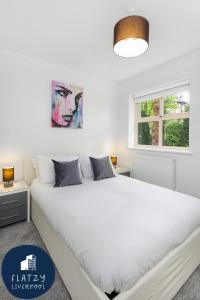 a bedroom with a large white bed and a window at FLATZY - Quiet Sefton Park Luxury Apartment in Liverpool