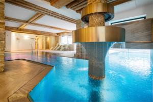 a swimming pool with a fountain in a building at Hotel NockResort in Bad Kleinkirchheim