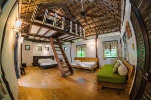 a living room with a large bed and a large window at Viajero Tayrona Hostel & Ecohabs in Buritaca