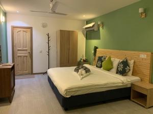 a bedroom with a bed with a stuffed animal on it at Koimala Hotel in Maamigili