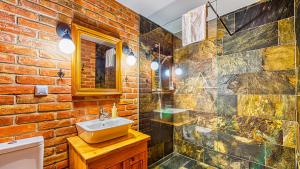 a bathroom with a sink and a brick wall at Aparthotel STARA PIEKARNIA by ROYAL APARTS in Szklarska Poręba
