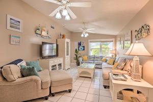 a living room with couches and a tv at Colorful Cape Coral Retreat with Screened Lanai! in Cape Coral