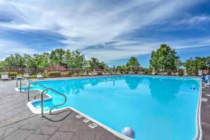 una gran piscina azul con sillas y árboles en Branson Resort Condo with Scenic Patio and Pool Access, en Branson