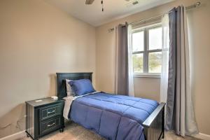 une chambre avec un lit avec une couette bleue et une fenêtre dans l'établissement Greenville House with Covered Patio, 2 Mi to Dtwn!, à Greenville